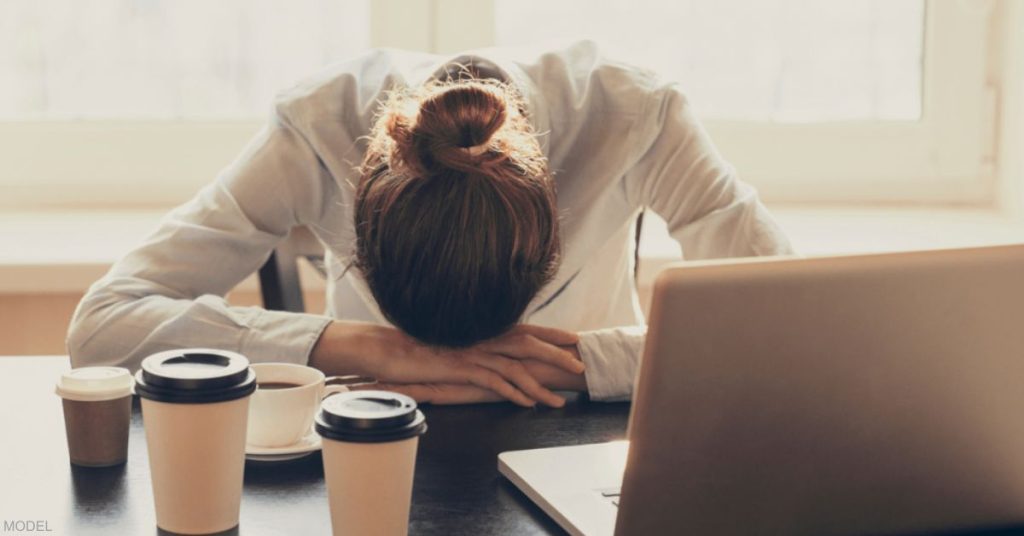 A woman with her head laying down on desk (model)