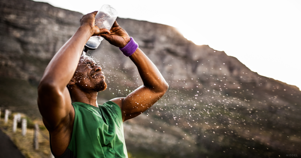 Man pouring water on himself