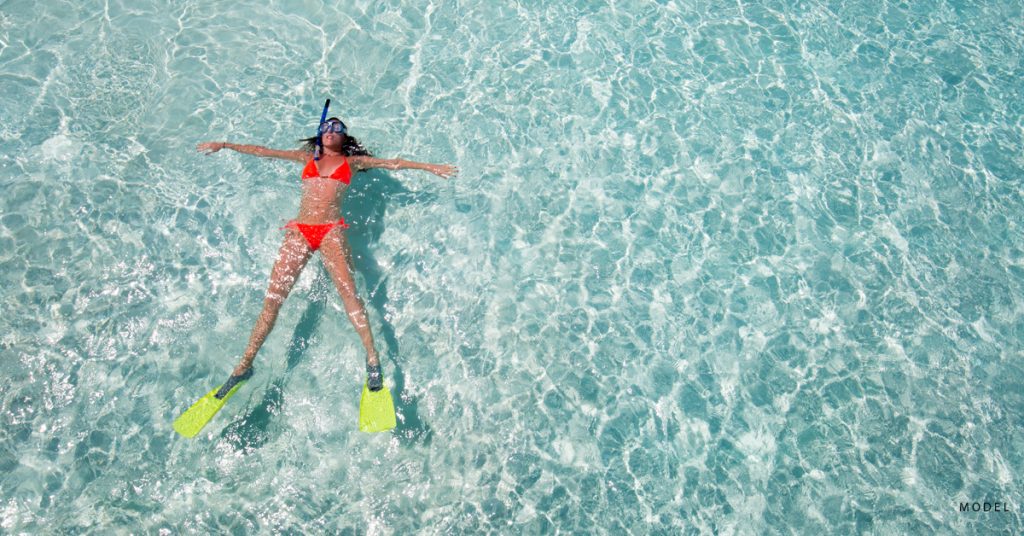 A woman floats on her back while snorkeling.