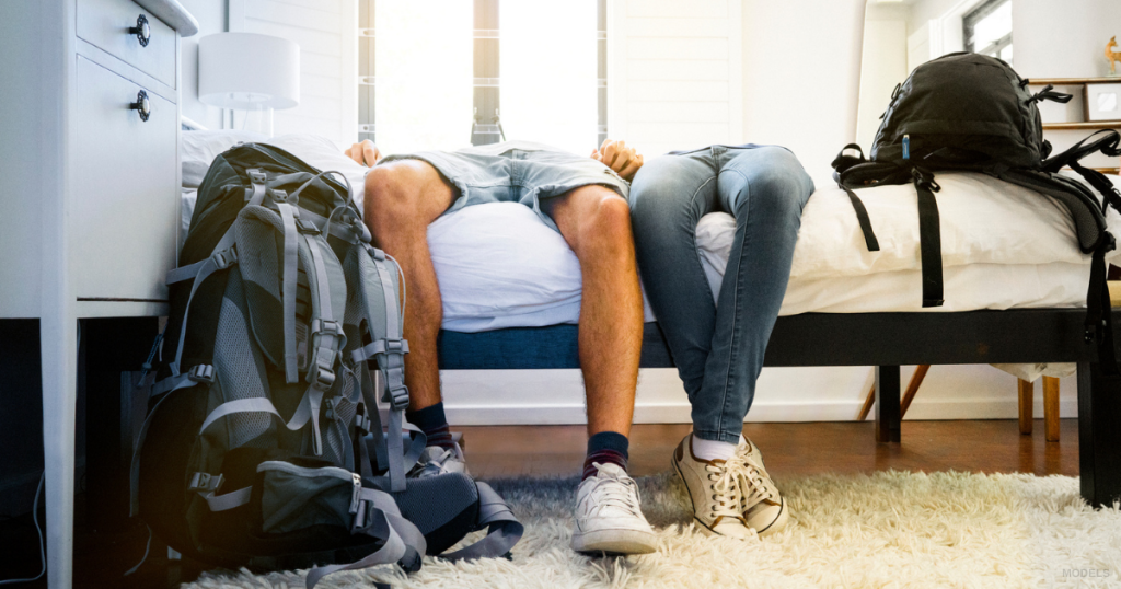 A man and woman rest on a bed.