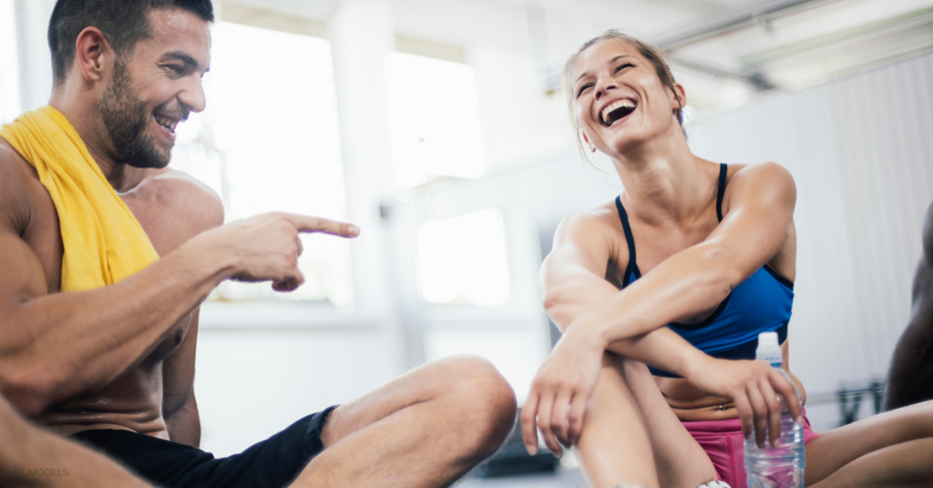 A man and woman stretch after a workout.