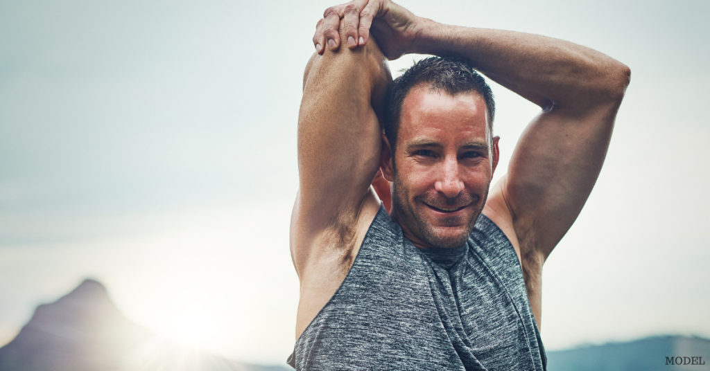 Middle aged man stretching before his work smiling (model)